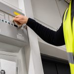 Electrician opening fire panel in office