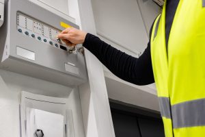 Electrician opening fire panel in office